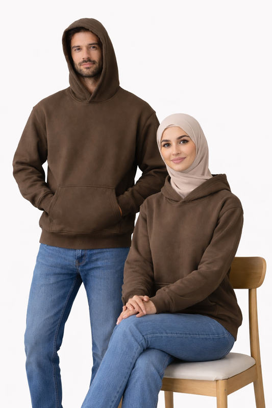Two people wearing brown hoodies on a white background